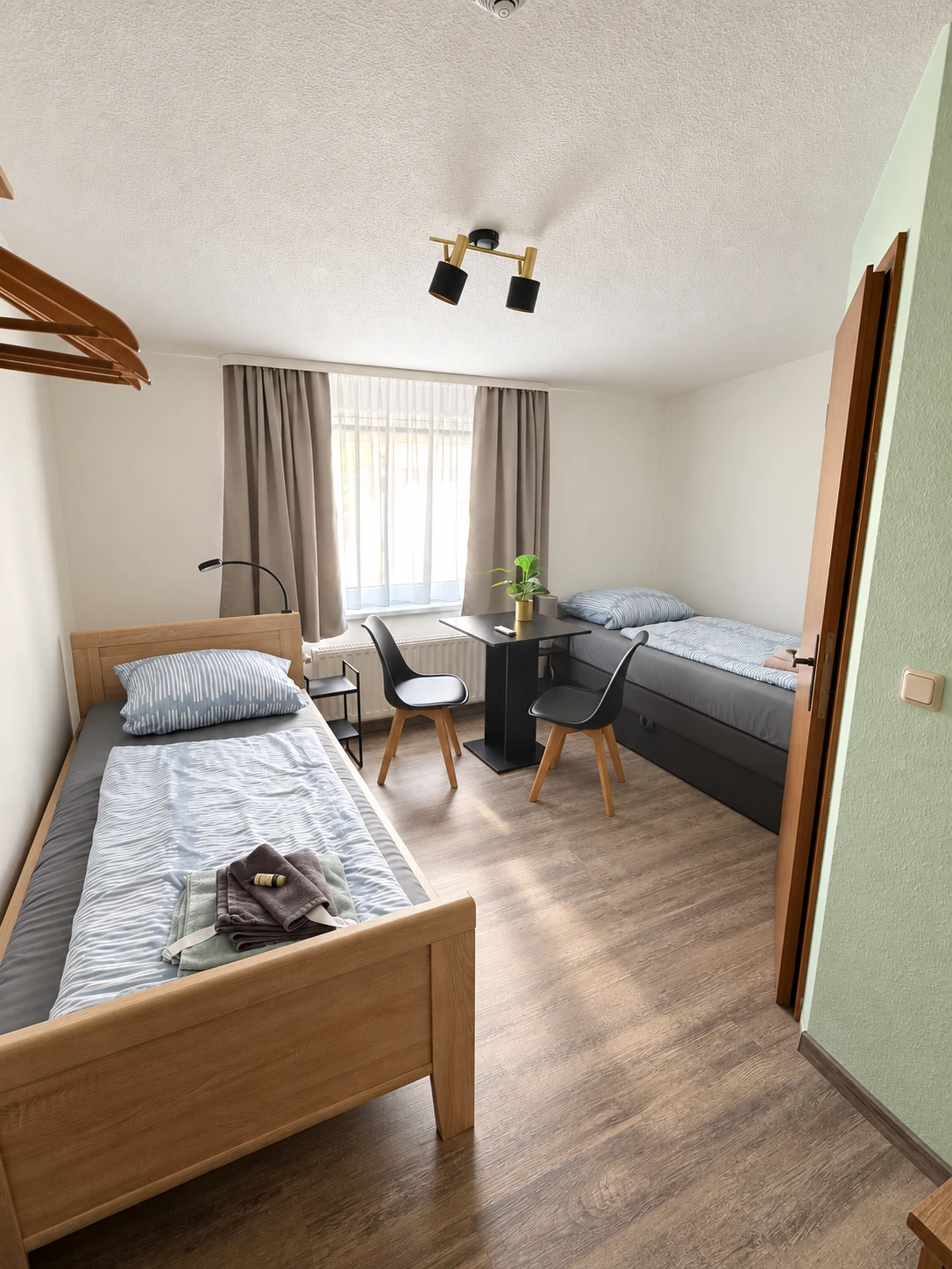 Twin-Zimmer im Hotel Hasa mit zwei getrennten Einzelbetten und Schreibtisch.
